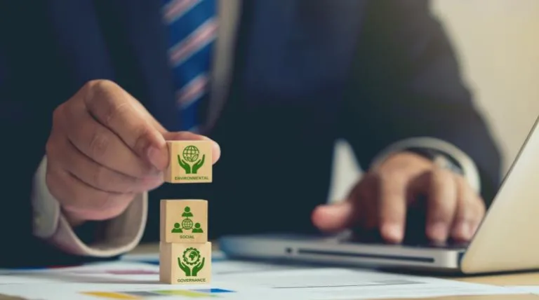 Señor con el portatil haciendo una torre con tres dados y logo